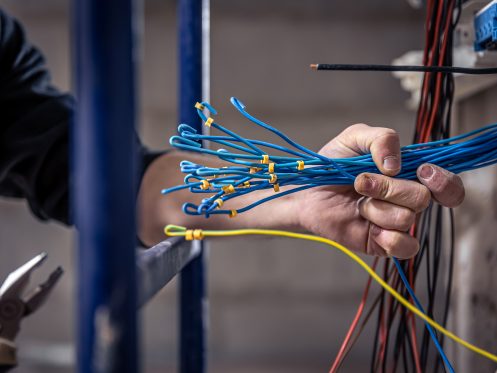 How do electricians run wires through existing walls?